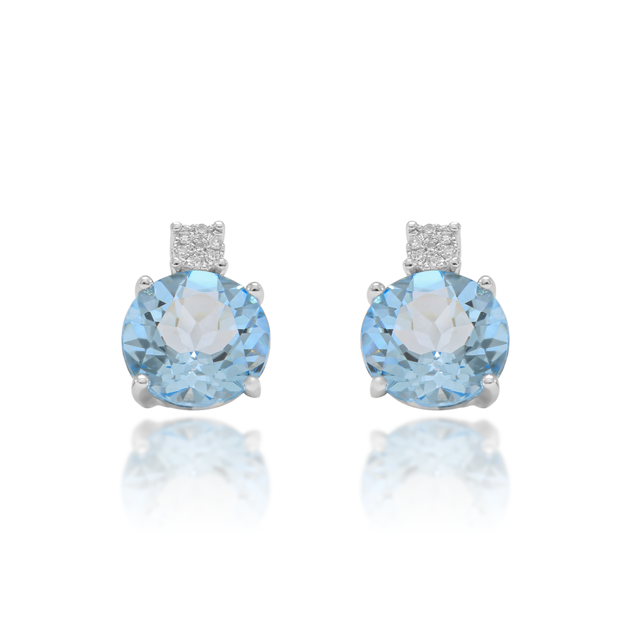 Pendientes realizados en oro blanco 18 quilates con 14 diamantes talla brillante y dos topacios azules. 