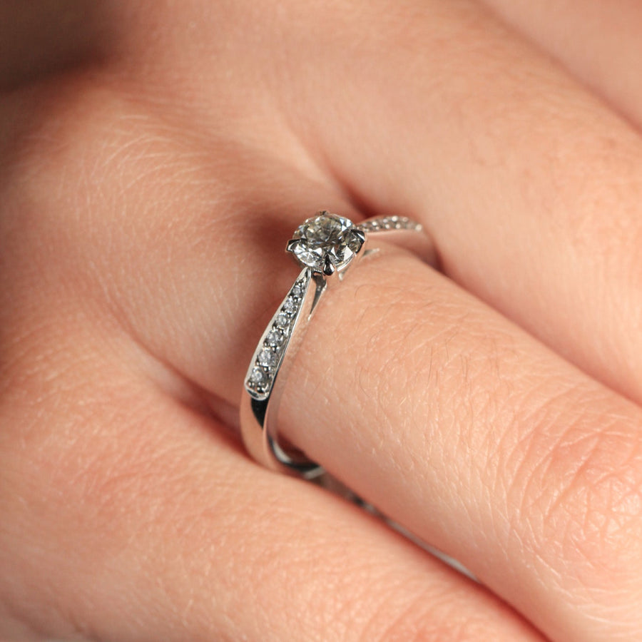 Sortija realizada en platino 960 con un diamante central talla brillante y 12 diamantes en los laterales. Joyería Pamplona