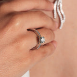 Anillo de platino 960 con un diamante solitario engastado en cuatro garras y diamantes en los laterales