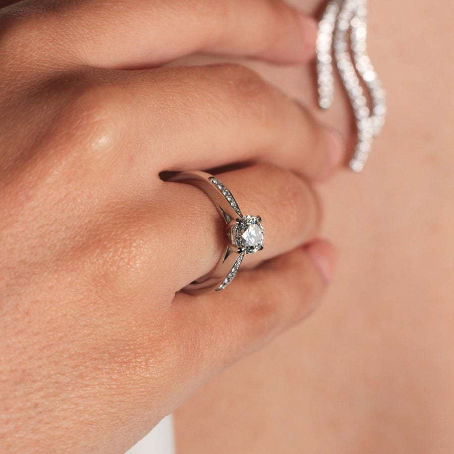 Anillo de platino 960 con un diamante solitario engastado en cuatro garras y diamantes en los laterales