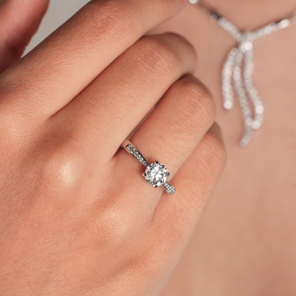 Anillo de platino 960 con un diamante solitario engastado en cuatro garras y diamantes en los laterales