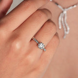 Anillo de platino 960 con un diamante solitario engastado en cuatro garras y diamantes en los laterales
