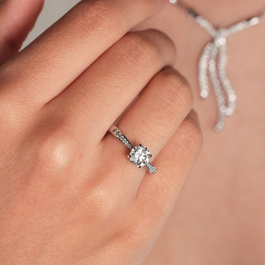 Anillo de platino 960 con un diamante solitario engastado en cuatro garras y diamantes en los laterales