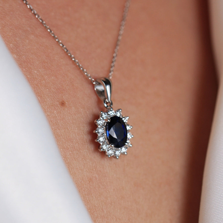Colgante estilo Lady Di con un zafiro central y orla de diamantes
